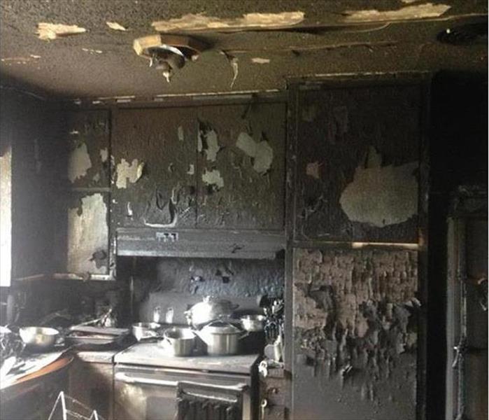 kitchen with cabinets ceiling and walls blackened from soot damage
