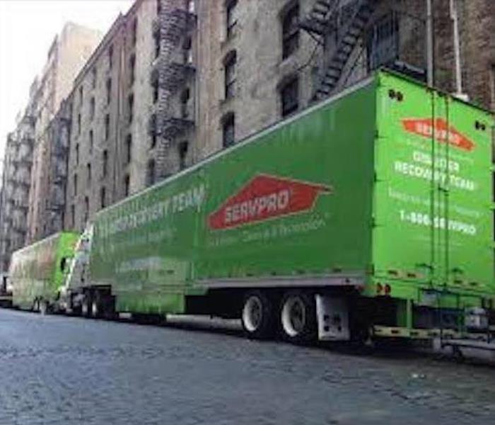 A Green 18 wheeler parked on a road 