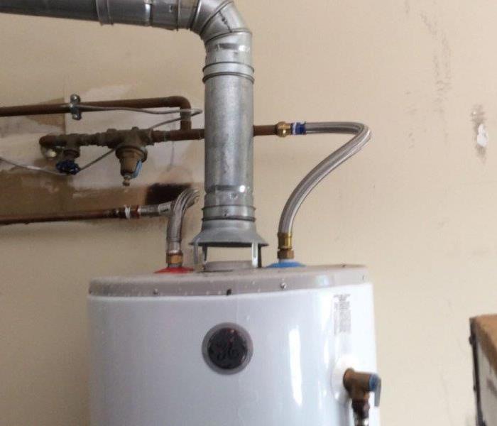 Hot Water heater with a large metal pipe coming out of it