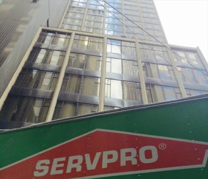 The top of a servpro truck parked next to a tall building 
