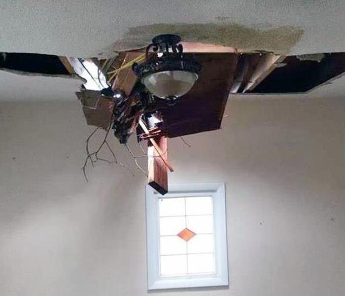 Wood beams falling through a ceiling with water damage