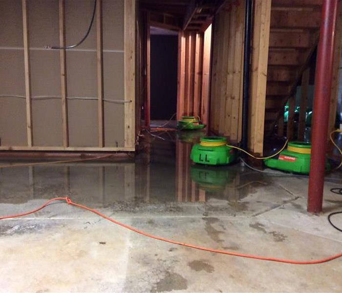 Standing water in a room with SERVPRO equipment on the floor