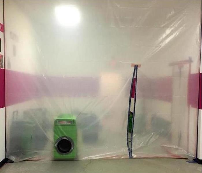 Plastic sheeting blocking off a room with SERVPRO equipment 