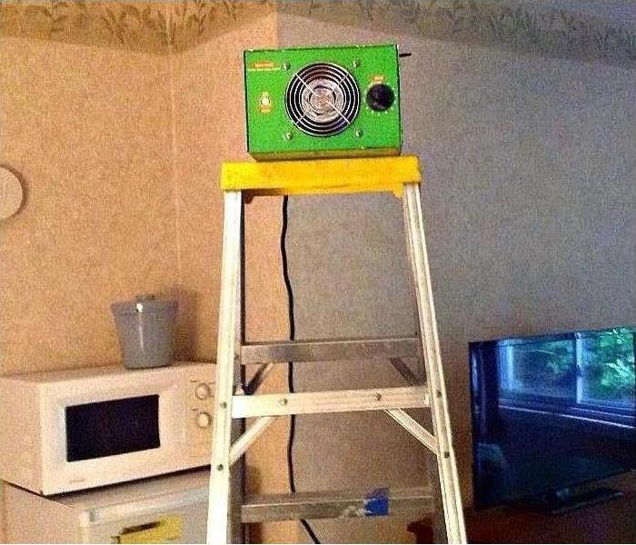 A small piece of SERVPRO equipment sitting on a ladder in a kitchen 