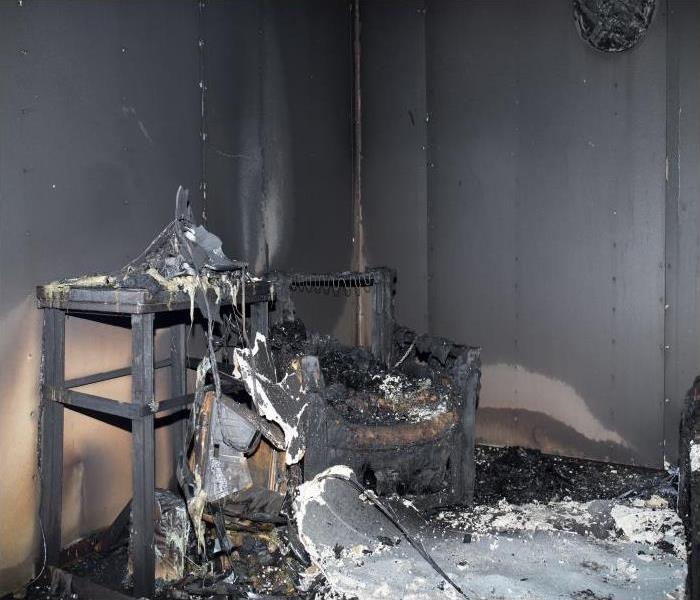 room with charred items covered in soot damage