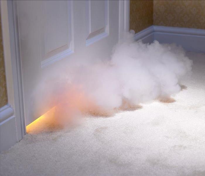 smoke billowing under a white door