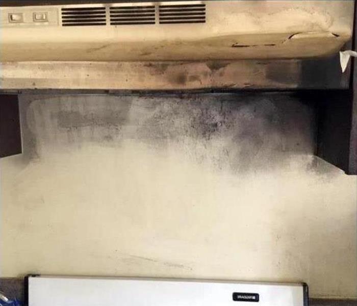 A stove top covered in grease and soot after a fire