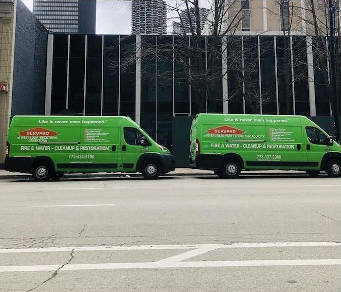 Two SERVPRO vans on a city street