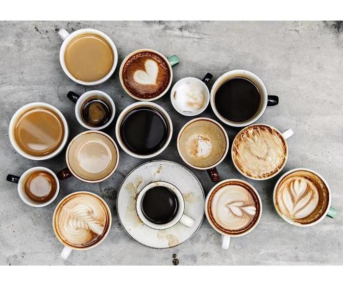 fifteen coffee cups sitting on a concrete table